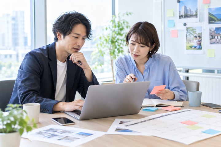 SNS投稿の計画を一緒に整理する2人の広報担当者